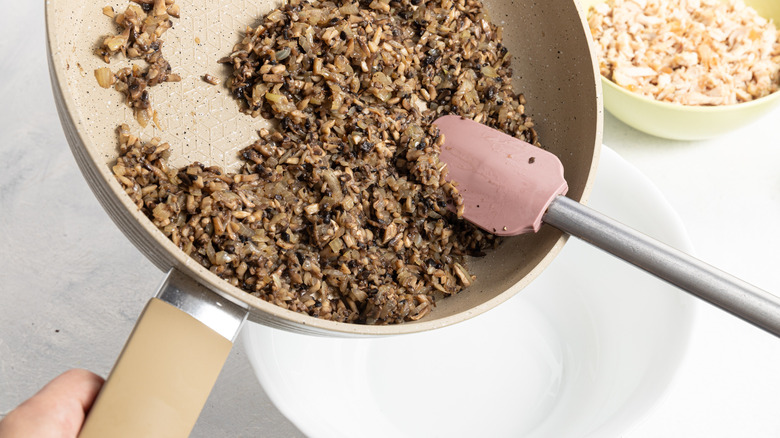 moving cooked mushrooms from pan to bowl