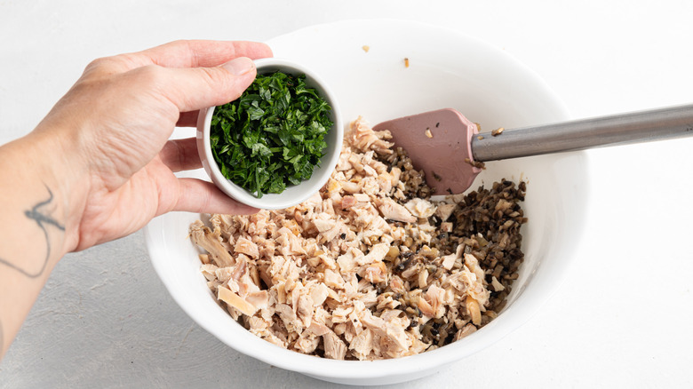 adding parsley to bowl of turkey and mushrooms