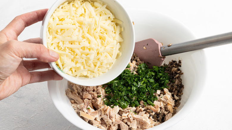 adding cheese to turkey and herbs mixture