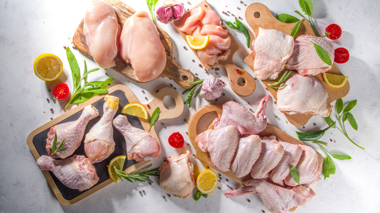 Various cuts of chicken on boards
