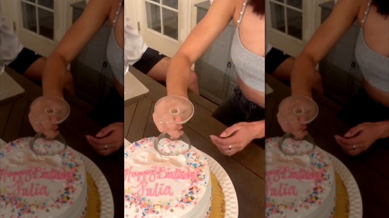person cutting cake with wine glass