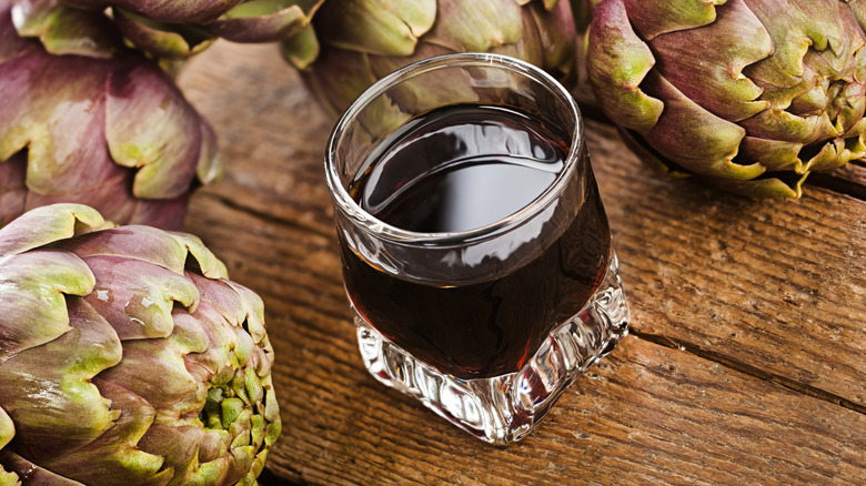 glass of Cynar with whole artichokes