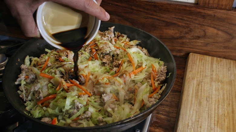 pouring sauce into stir fry