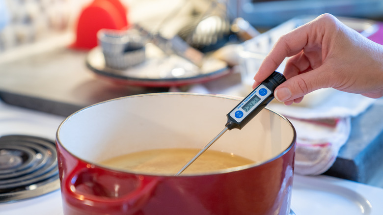 Checking the temperature of oil for deep frying with a probe thermometer