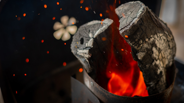 lump charcoal in a charcoal chimney on smoker