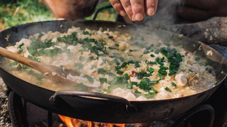 rice and chicken cooking in a wok outdoors