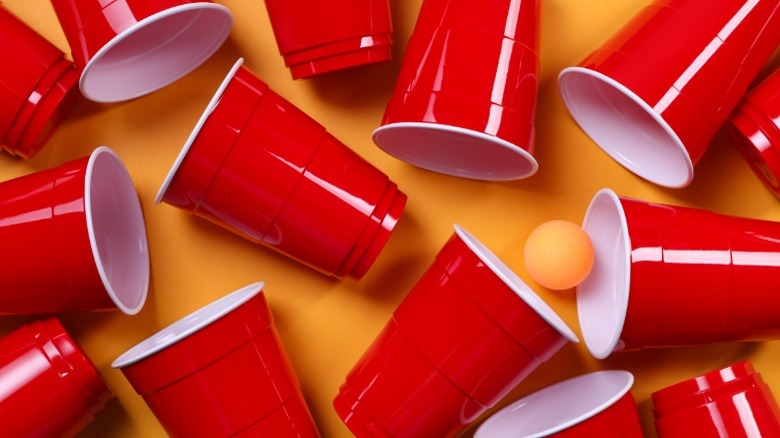 Red solo cups tipped over on an orange background 