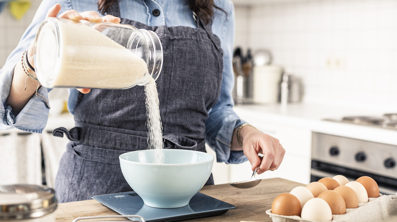 A baker measures ingredients with a digital scale