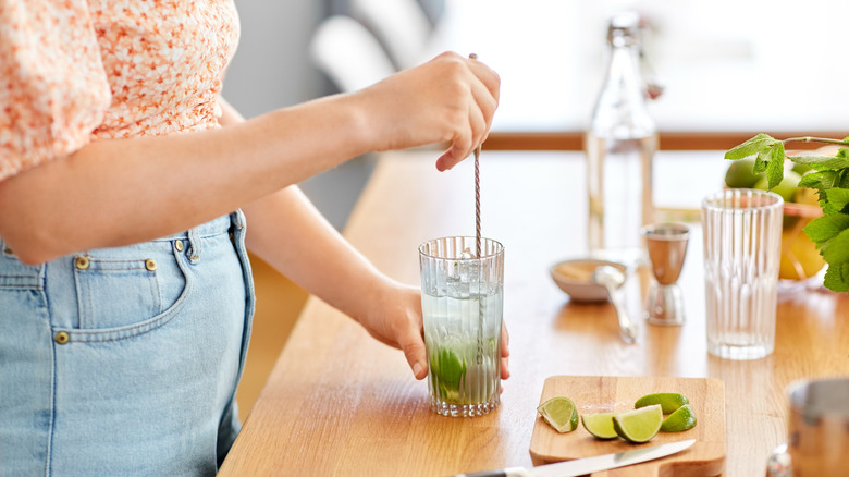 Person stirring a cocktail with a bar spoon