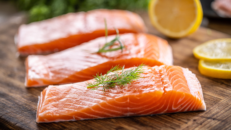 Raw salmon filets topped with herbs