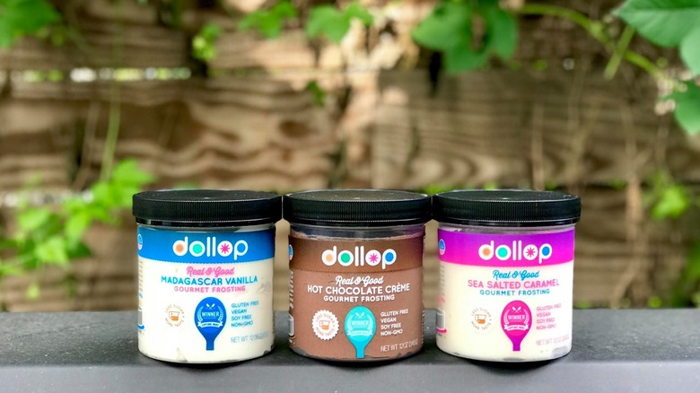 Tree jars of Dollop Gourmet-brand icing sit on a cement ledge