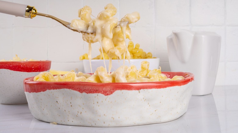 Mac and cheese being lifted from bowl with a fork