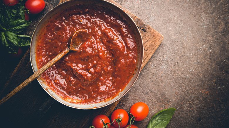 Pasta sauce in pot surrounded by tomatoes