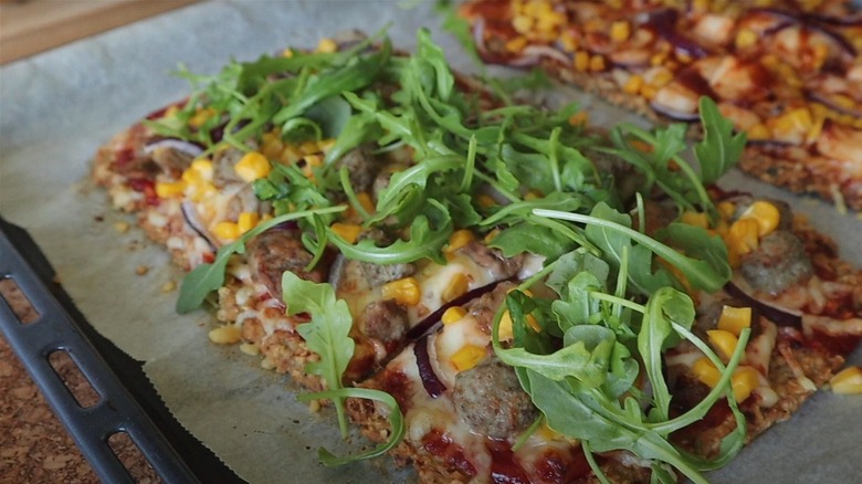 Two pieces of tuna crust pizza with toppings including arugula