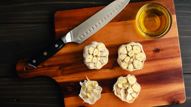 Garlic bulbs on a wooden board with knife