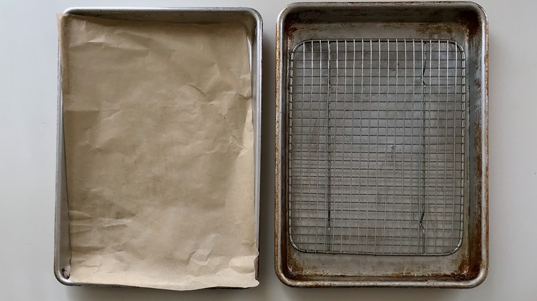 two baking pans with parchment paper and wire rack