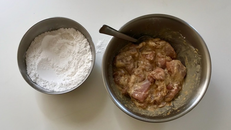 flour with marinated raw chicken