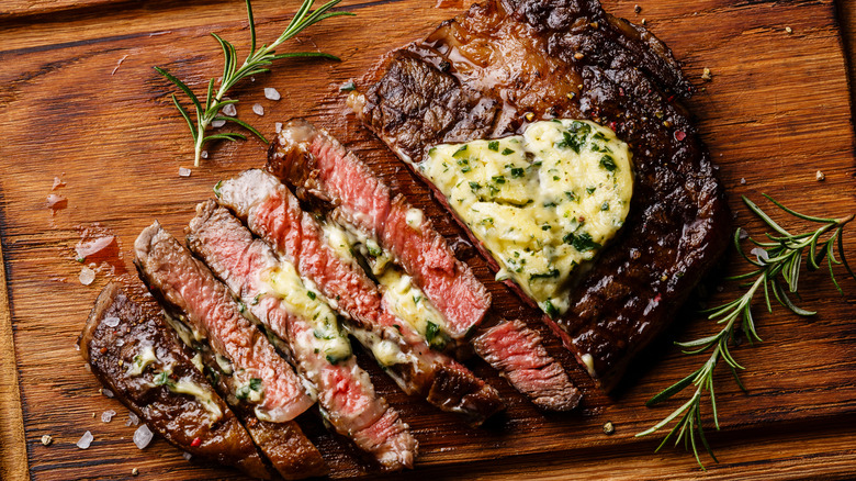 Sliced cooked steak topped with herb butter