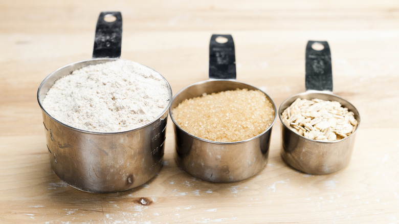 Measuring cups of sugar, flour, and oats