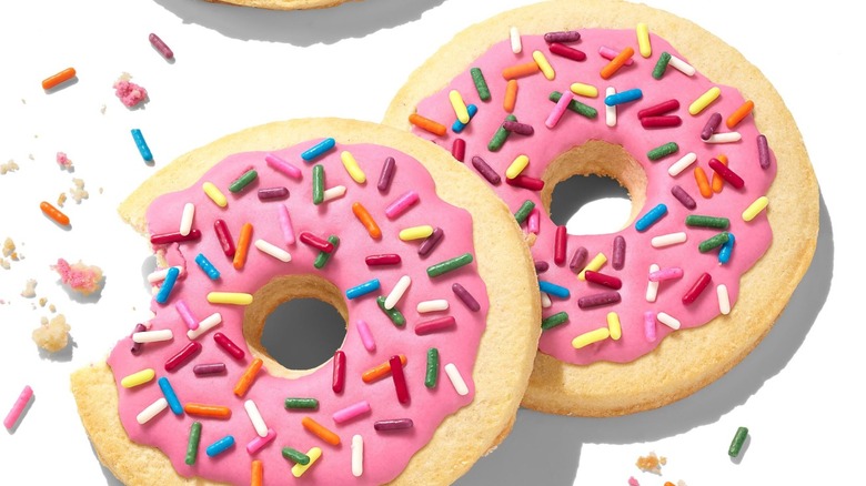 Two Dunkin' holiday sugar cookies, one with a bite taken out of it