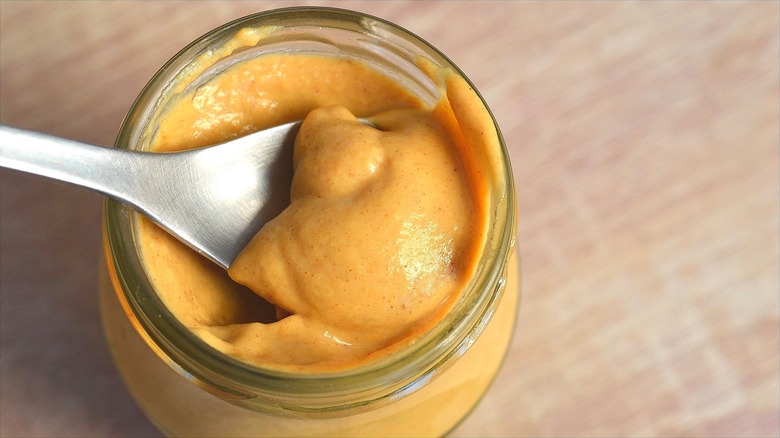 Spoon in jar of dijon mustard