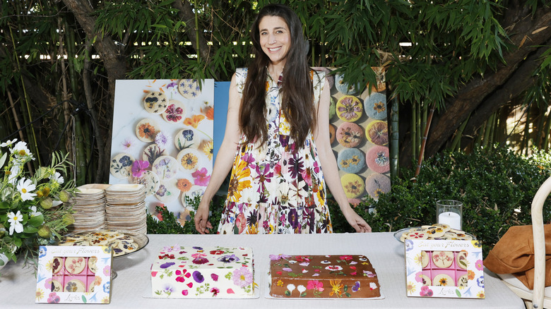 Loria Stern smiling in front of table of floral baked goods