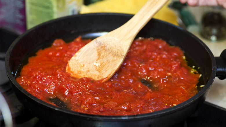 Tomato sauce in a pan with wooden spoon