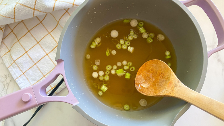 broth and scallions in pot