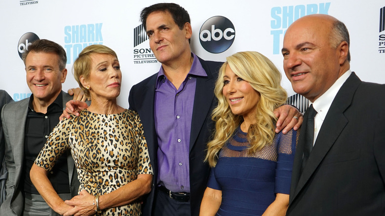 The cast of Shark Tank n an ABC red carpet posing and smiling