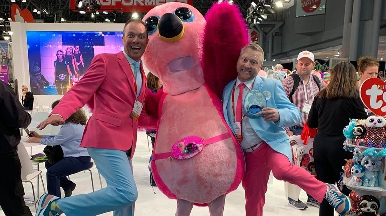 Chris McGill and Scott Houdashell at a toy convention pose with a person wearing a Beanie Baby costume