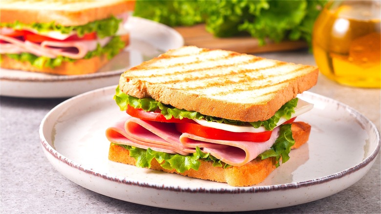 Ham sandwiches with tomato and lettuce on toasted white bread