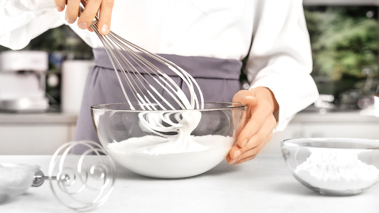 Woman whipping cream with whisk