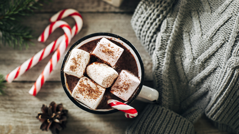 a mug of hot chocolate with marshmallows and candy canes