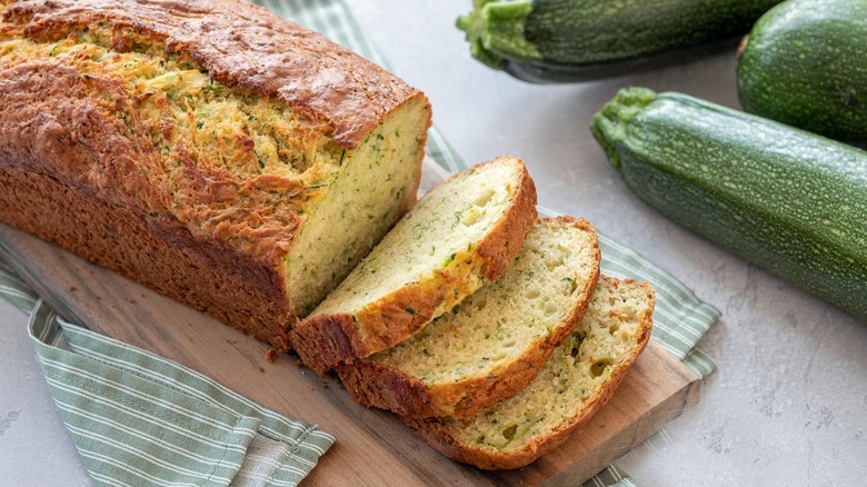 sliced zucchini bread next to zucchini