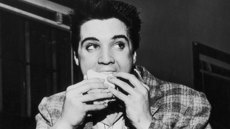 Elvis eating a square burger or sandwich