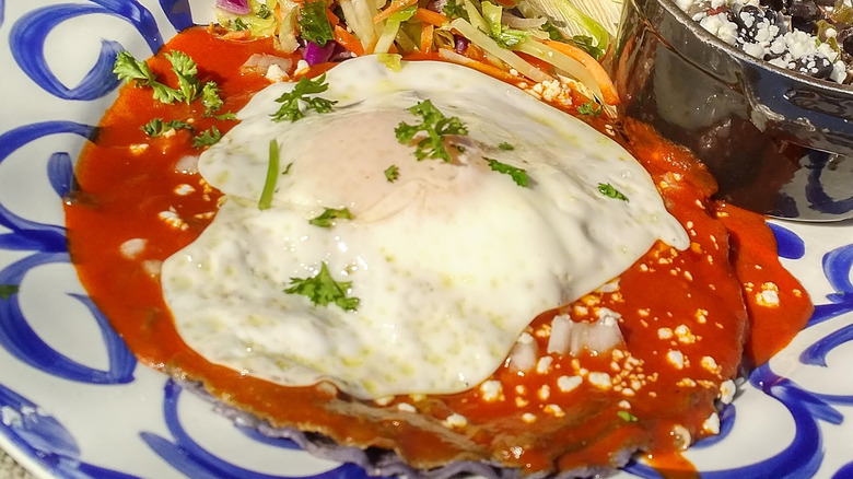 Fried egg on top of enchilada sauce