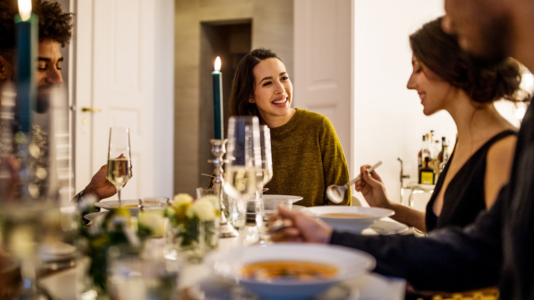 Friends enjoying light conversation during dinner at home