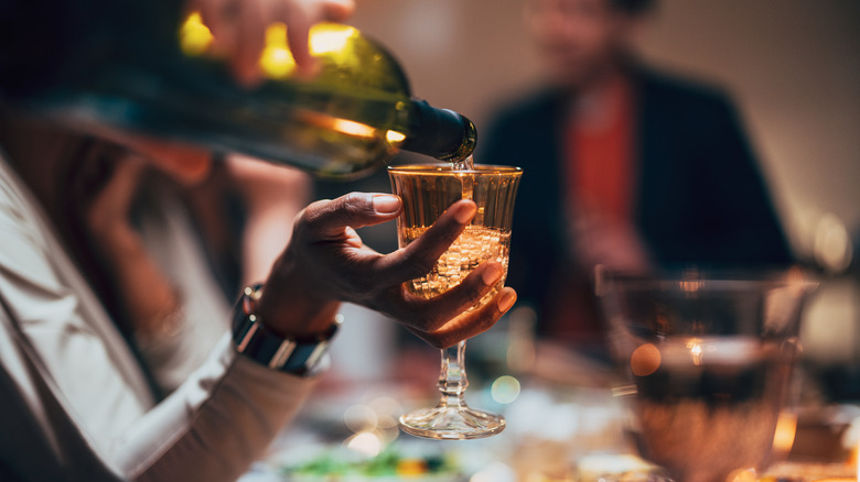 Pouring wine for guest at a dinner party