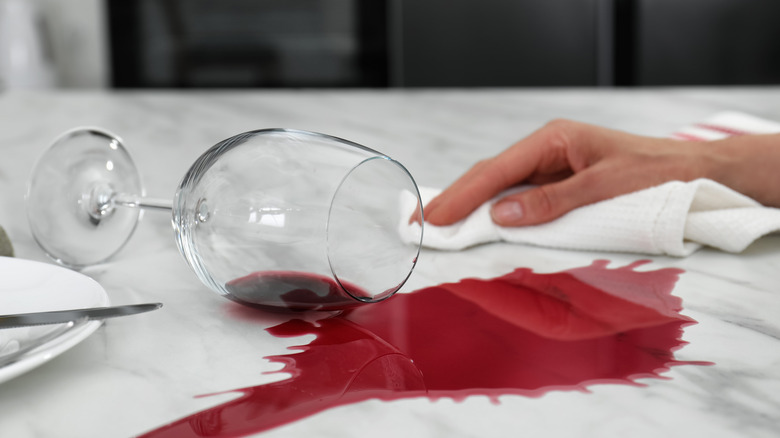 Woman wiping up spilled wine glass with cloth