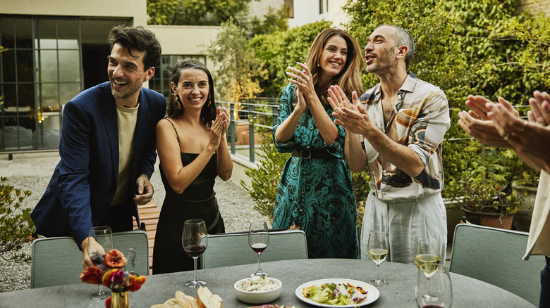 Guests clapping at outdoor dinner party