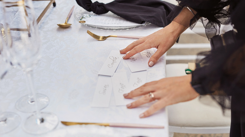 Woman arranging place cards on formal dining table