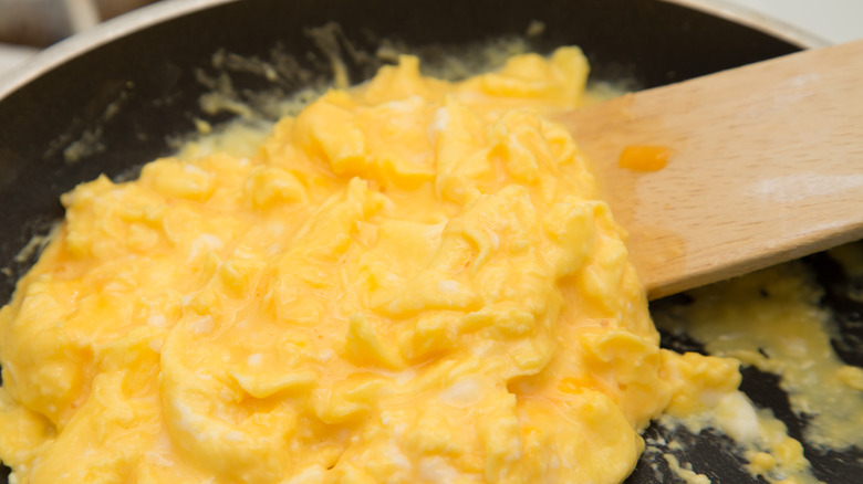 stirring eggs in skillet