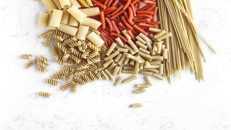 A variety of dried pasta shapes are grouped together.