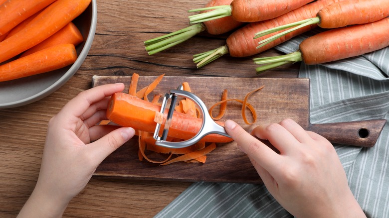 Hands peeling a carrot