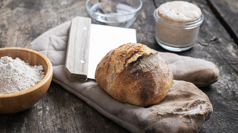 Loaf of bread with knife and oven mitt