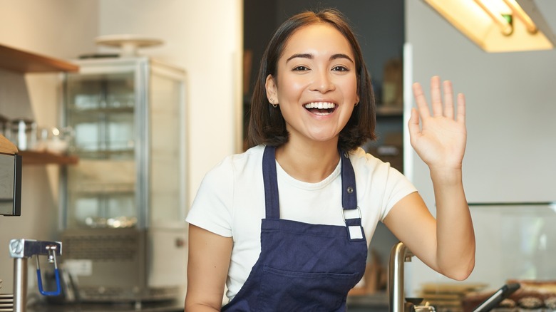 Japanese restaurant worker waving goodbye