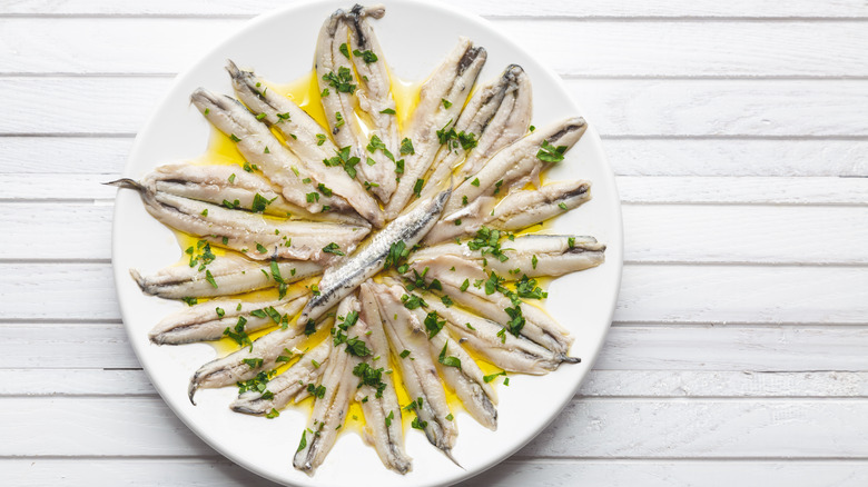 fresh anchovies on a white plate