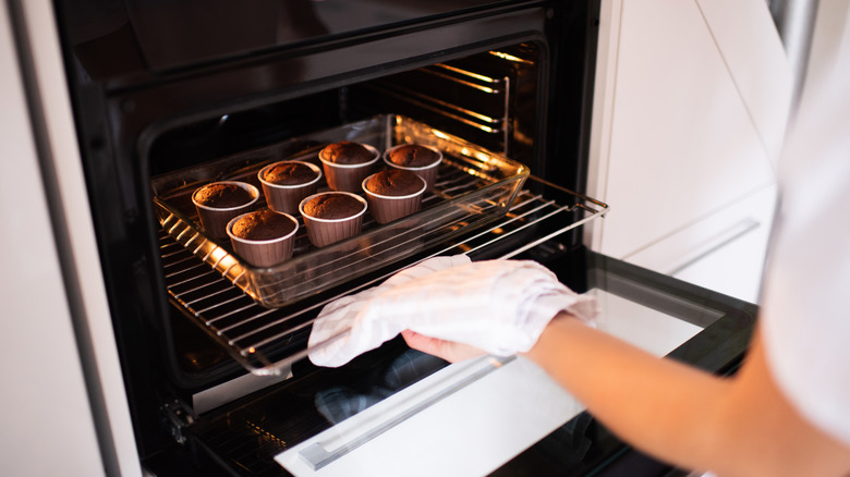 Chef pulling oven rack with towel