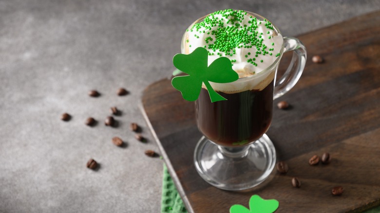 Irish coffee garnished with green sprinkles and shamrock