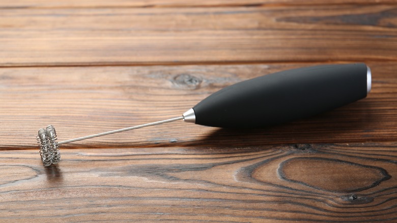 Handheld milk frother on wooden table